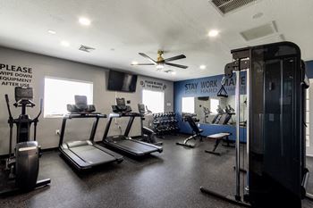 A gym with treadmills, elliptical machines, and a weight machine.